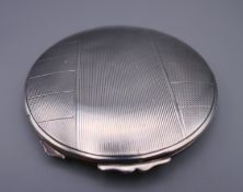 An Art Deco style silver compact. 8.5 cm diameter. 86.1 grammes total weight.
