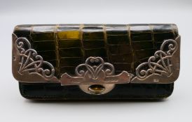 A crocodile skin purse with silver mounts. 12 cm long x 6 cm high.