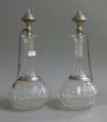 A pair of cut glass decanters with Continental silver mounts. 34 cm high.