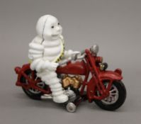 A cast iron Michelin Man on motorcycle. 16 cm high.