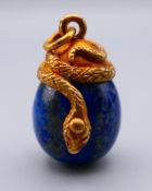 A silver serpent mounted lapiz lazuli egg form pendant bearing Russian marks. 3 cm high.