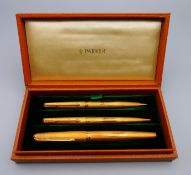 A boxed set of two 18 ct gold cased Parker pens and one 18 ct gold cased pencil. Largest 13.