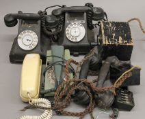 A box of various vintage telephones, including bakelite examples.