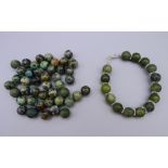 A jade and silver bracelet and a quantity of loose jade beads. Bracelet 19 cm long.