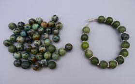 A jade and silver bracelet and a quantity of loose jade beads. Bracelet 19 cm long.