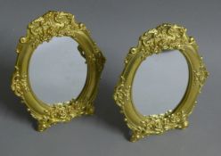 A pair of brass strut mirrors. 23 cm high.