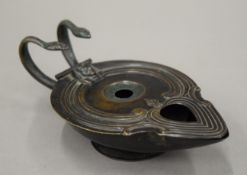 A classical shaped patinated bronze two handled oil lamp. 17.5 cm long.