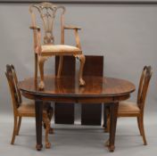 An early 20th century mahogany dining table and a set of six chairs.