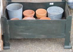 A green metal garden planter and garden pots.