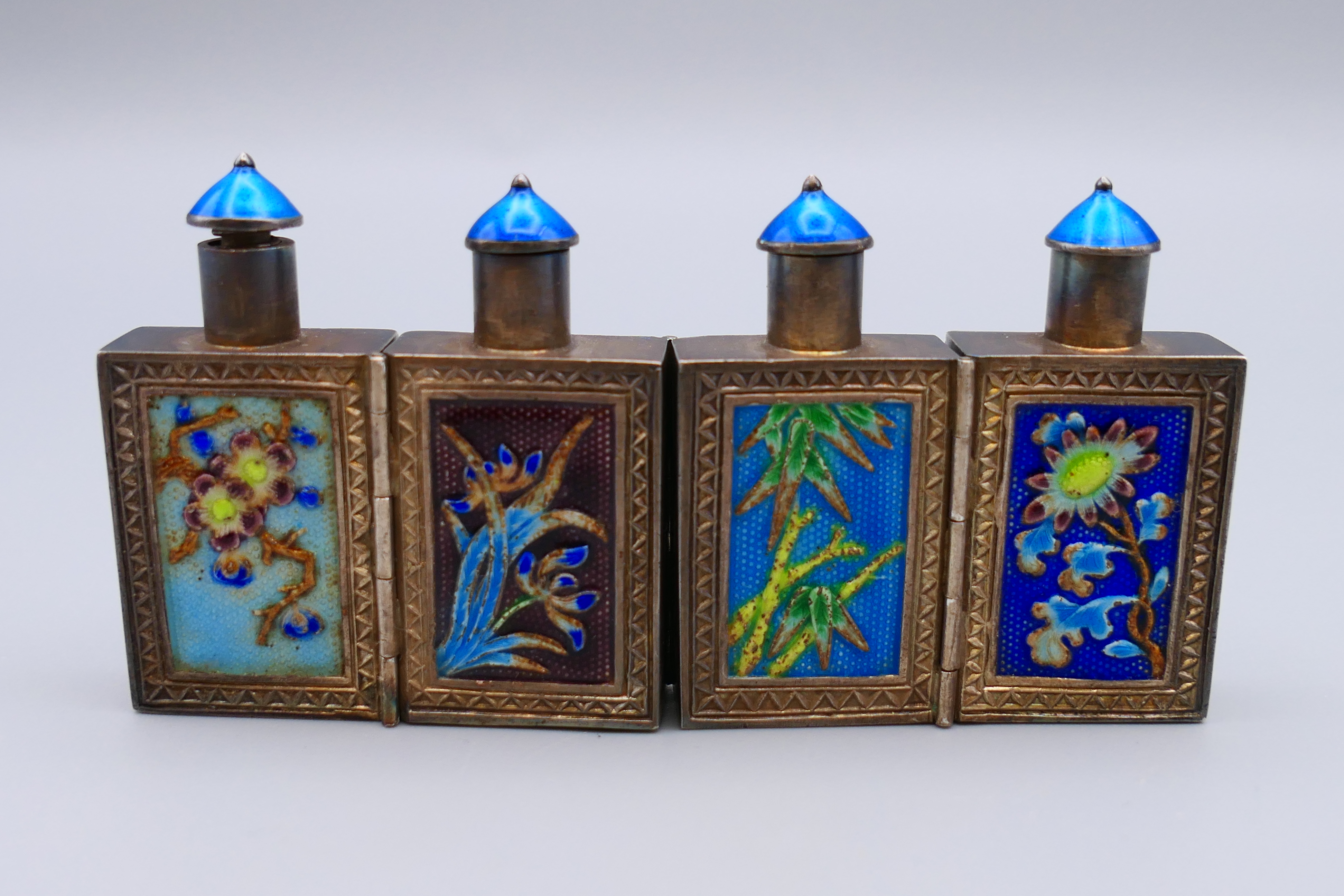 A set of four Chinese silver and enamel folding hinged snuff bottles. 4 cm high, 8 cm long opened.