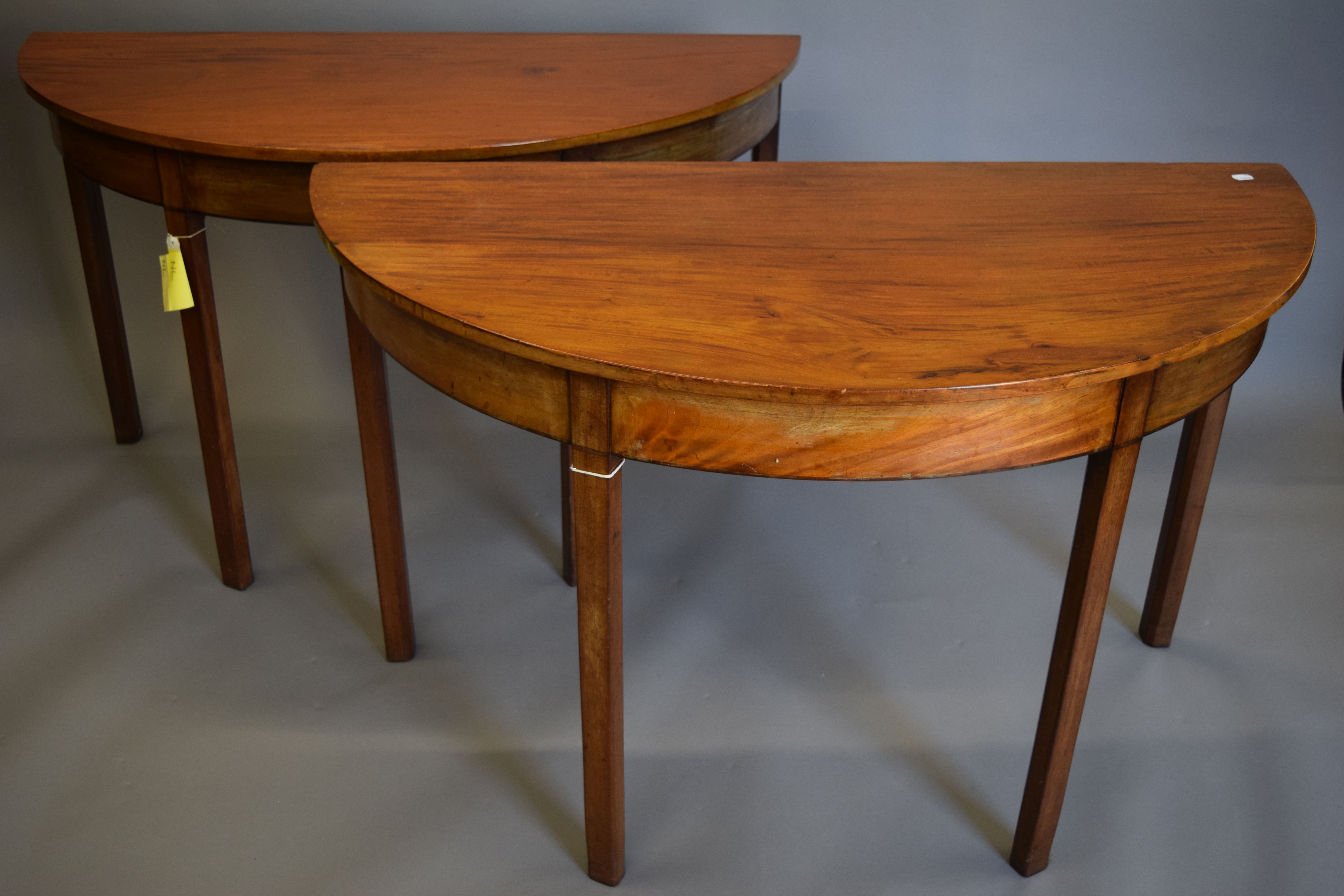 Two 19th century mahogany demi-lune tables. Each 121 cm wide, 72 cm high.