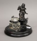 An ebonised desk stand surmounted with a cherub. 17 cm high.