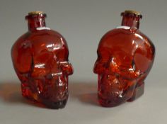 A pair of ruby glass skull bottles. 15 cm high.