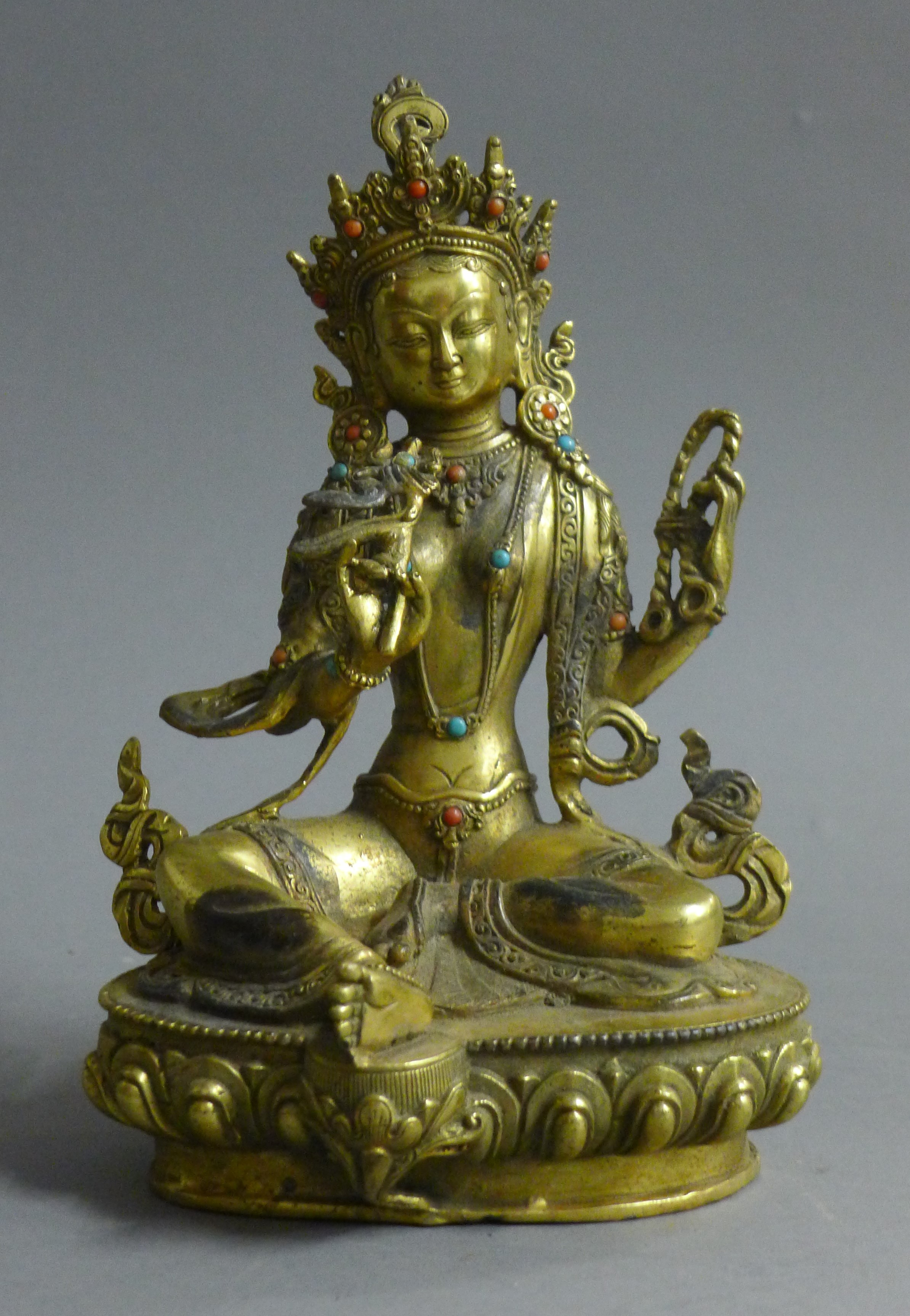 A gilt bronze figure of Buddha decorated with turquoise and coral. 21.5 cm high.