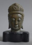 A bronze bust of buddha mounted on a wooden base. 14.5 cm high overall.