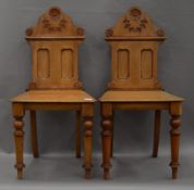 A pair of Victorian walnut hall chairs. 45 cm wide.