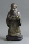 A bronze figure of Shou Lao holding a peach, standing on a plinth base. 33 cm high overall.