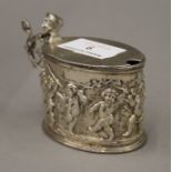 An embossed silver mustard pot, lacking liner. 7 cm high. 3.6 troy ounces.