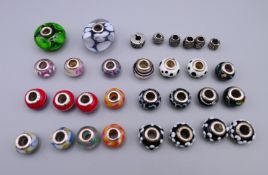 A collection of silver mounted glass beads. Each approximately 5 mm inner diameter.