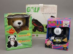 Three boxed novelty telephones, a golf bag, a teddy bear and a magic 8 ball.