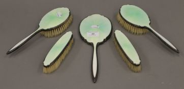 A silver and enamel dressing table set.
