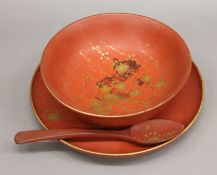 A Japanese lacquered bowl, plate and spoon. The bowl 24.5 cm diameter.