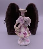 A 19th century Continental porcelain snuff bottle in the form of a lady holding a fan,