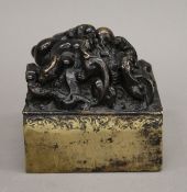 A large Chinese cast bronze seal, the boss of writhing Qilongs. 8.5 cm high.