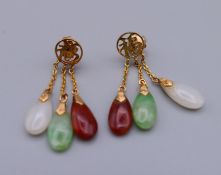 A pair of 14 K gold mounted jade drop earrings. 3 cm high.