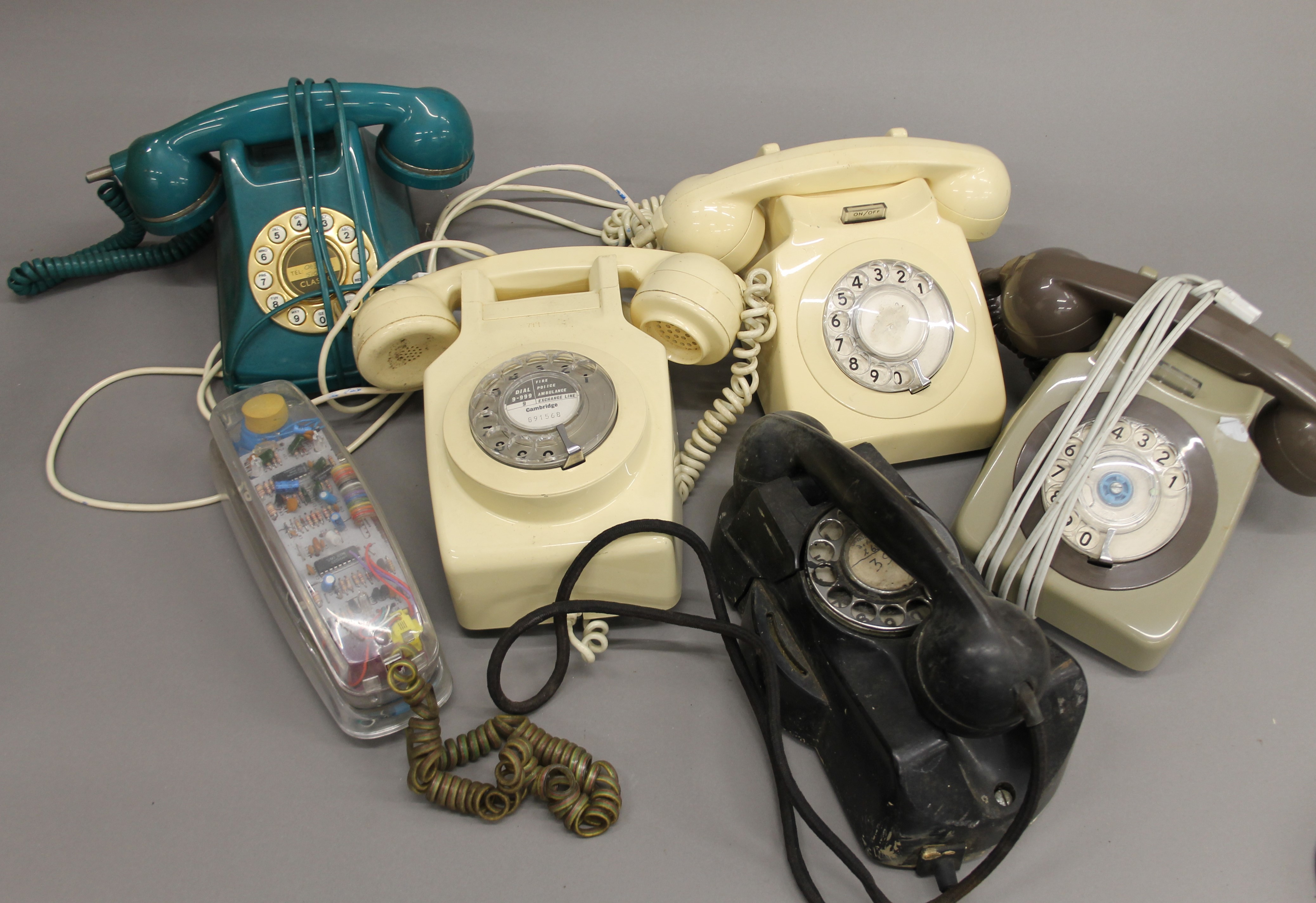 A box of various vintage telephones.