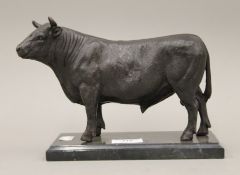 A bronze model of a bull on a plinth base. 24 cm long.