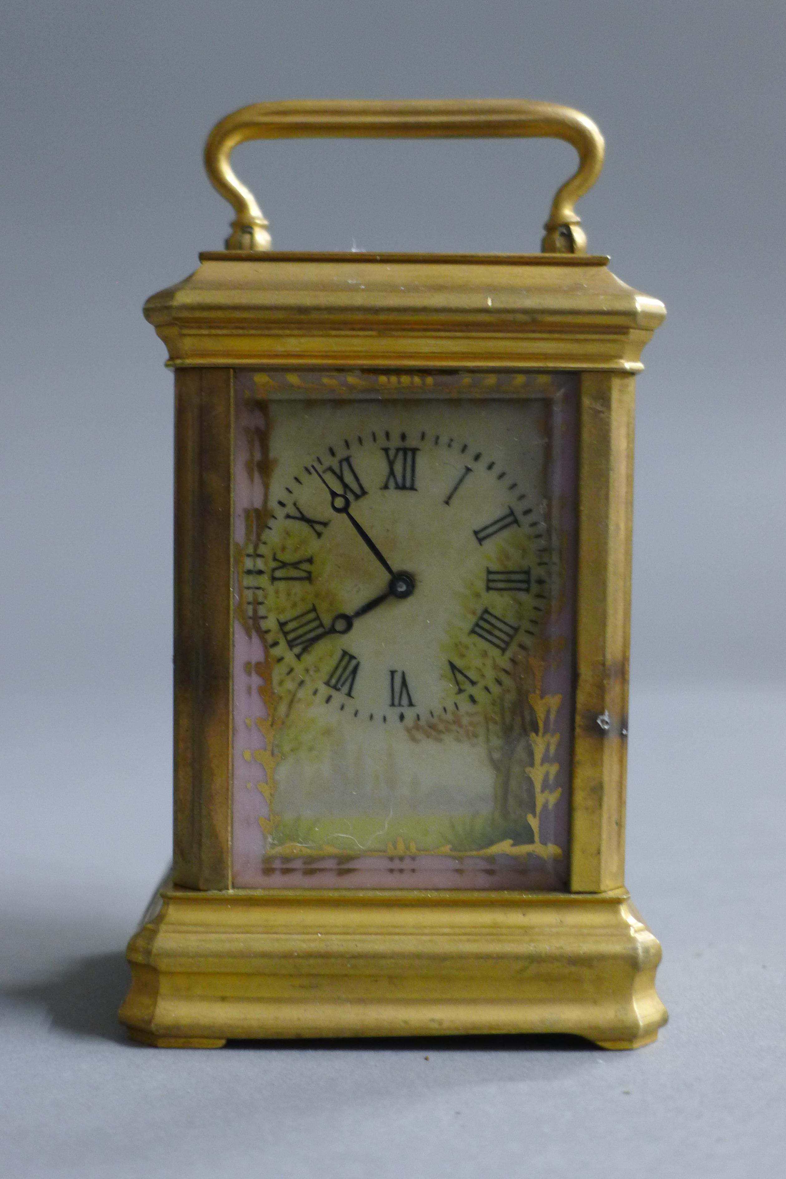 A miniature carriage clock set with porcelain panels. 9 cm high.