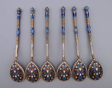 A set of six silver and enamel teaspoons bearing Russian marks. Each 10.75 cm long. 79.