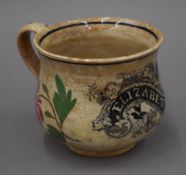 A 19th century transfer printed and painted pottery mug, inscribed 'Elizabeth'. 8.5 cm high.