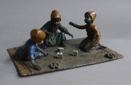 A cold painted bronze model of three boys playing dice. 20 cm wide.