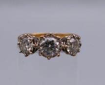An 18 ct gold three stone diamond ring, the central diamond approximately 0.