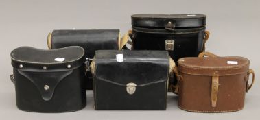 Five cased pairs of binoculars.