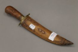 A carved wooden sheathed knife.