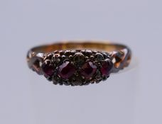 An 18 ct gold diamond and garnet ring. Ring size J/K. 1.6 grammes total weight.