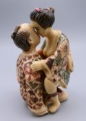 A Japanese figure of an amorous couple. 8 cm high.