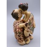 A Japanese figure of an amorous couple. 8 cm high.