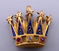 An unmarked gold, enamel, diamond and ruby set crown form pendant. 2 cm x 2.25 cm.