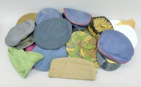 A quantity of old military berets, hats and Naval jackets.