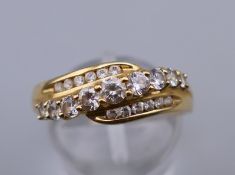 A 14 ct gold and cubic zirconia crossover half eternity ring. Ring size S. 3.3 grammes total weight.