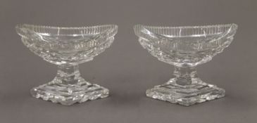 A pair of Regency cut glass salts and a pair of silver salt spoons. The former 9.5 cm wide.