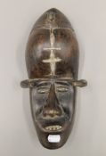An African tribal carved wooden wall mask. 30 cm high.