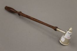 A silver candle snuffer with turned wooden handle. 28 cm long.