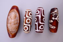 Four dzi beads. Largest 5 cm long.