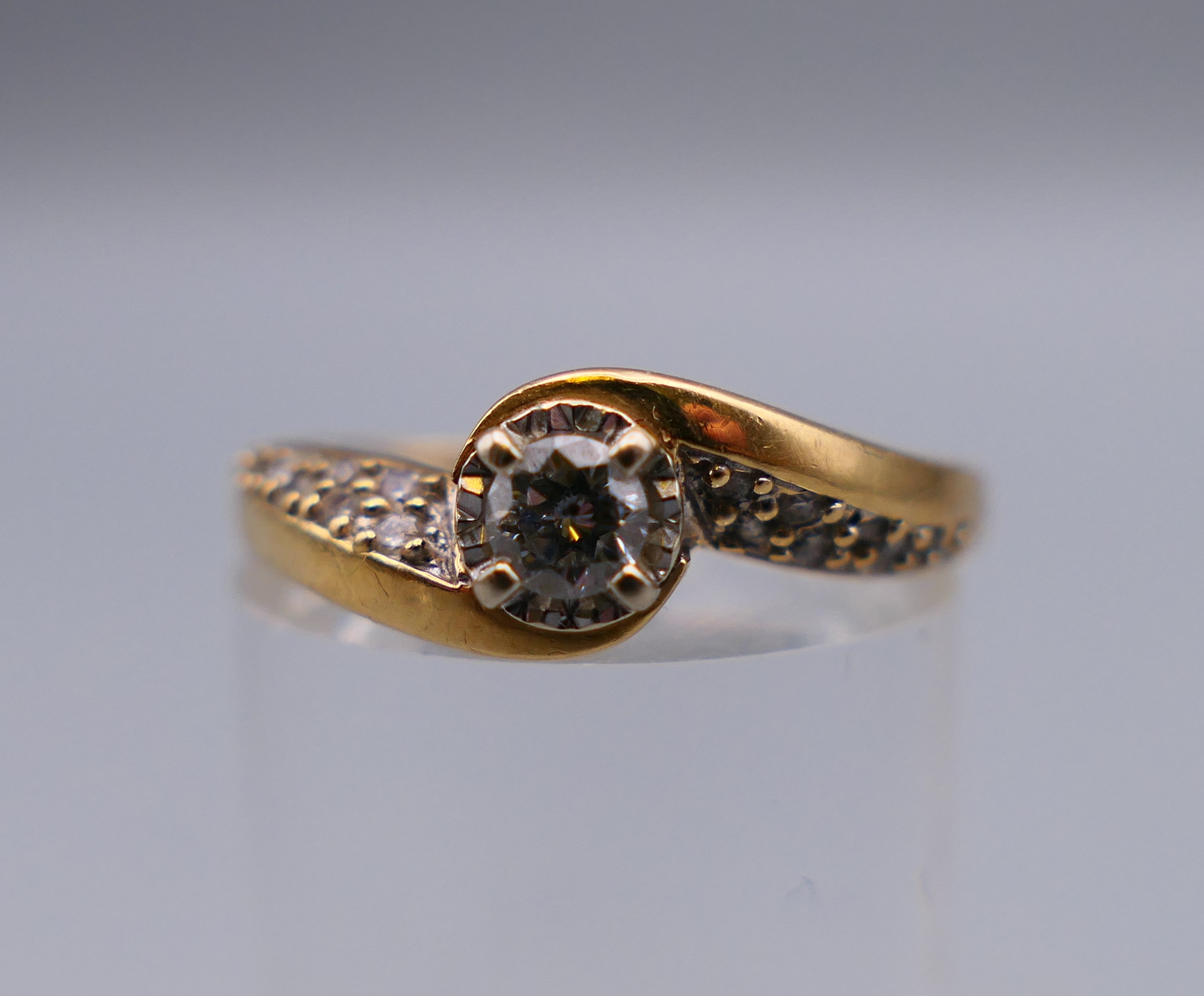 An 18 ct gold and diamond crossover ring, approximately 0.25 carat of diamonds. Ring size P/Q. 4.