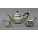 A silver three-piece tea set. The teapot 29 cm long. 854.6 grammes total weight.